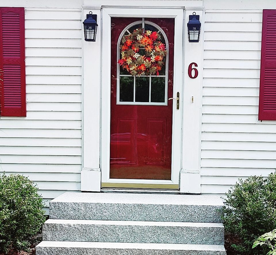 A red door with wreath on the front of it.