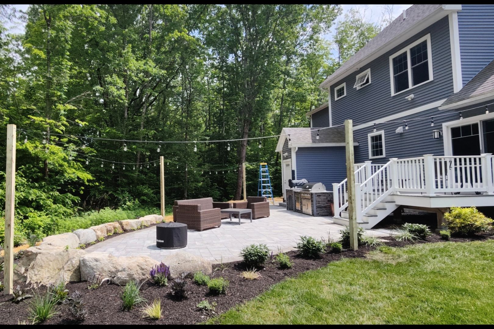 68026f8c1f6ca_Screenshot_20250411_125616_Gallery(1) (1) A backyard with a fire pit and patio furniture.