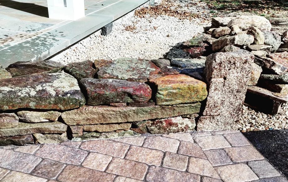 A brick walkway with rocks and gravel on the side.