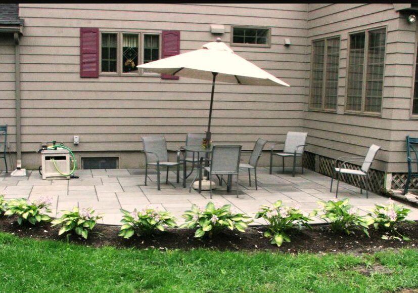 Screenshot_20220126-105541__01__01 A patio with an umbrella and chairs on the side of the house.